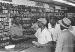 Joe Louis shaking hand of man in liquor store by Harold Hargis
