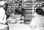 Joe Louis behind the counter of liquor store with hands on hips by Harold Hargis