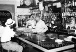 Unidentified man & woman standing behind a bar waiting on patrons by Harold Hargis