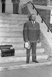 Unidentified man with suitcase pictured on church steps by Harold Hargis