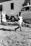 Child Playing in the Yard of a House by Harold Hargis