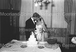 Bride and Groom kissing in front of Wedding Cake by Harold Hargis