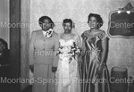 Bride with 2 wedding guest. Bride holding flowers by Harold Hargis