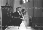 Bride and Groom feeding each other wedding cake. by Harold Hargis