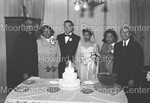 Bride and Groom pose with priest and wedding guest by Harold Hargis