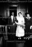 Bride and 2 unidentified people standing in the aisle by Harold Hargis