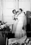 Bride preparing for her wedding; helped by a young Female Graduate by Harold Hargis