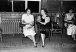 Two Women Pose for Photograph While Seated at Fraternity Social Event by Hargis Harold