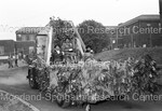 A float covered in greenery during the homecoming parade by Harold Hargis