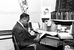 Man Photographed Sitting at Desk - 1 by Harold Hargis
