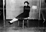 Young woman seated on a small table; legs prosed in front of her - 1 by Harold Hargis
