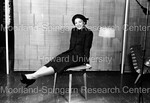 Young woman seated on a small table; legs prosed in front of her - 2 by Harold Hargis
