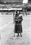 Young woman about to address the microphone at the stadium by Harold Hargis