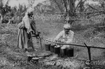 Two Women Roasting Breadfruit
