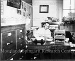 E.B. Henderson at desk