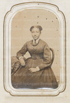 Unidentified woman posing while sitting in chair at table